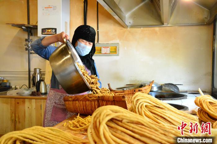 图为51岁的回族商户马占梅在平安驿经营有一家馓子花花店。　鲁丹阳 摄