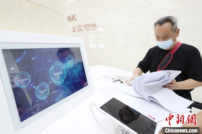 当事人在工作人员帮助下使用智能系统 李金星 摄