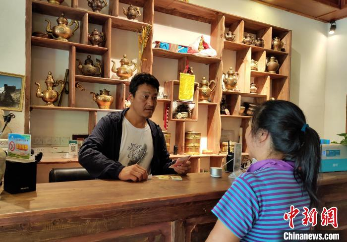 洛太在民宿前台接待游客。　王鹏 摄