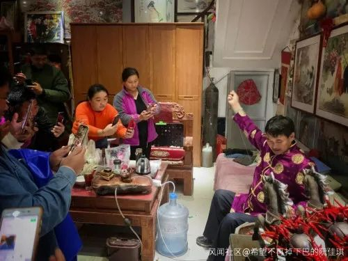 朱之文坐在堂屋的沙发上给辣椒穿线 图自人物