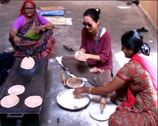 ▲大壶节上，义务为巴巴和信众做饭的印度妇女，吕炜克（中）也参与其中。梁子 摄