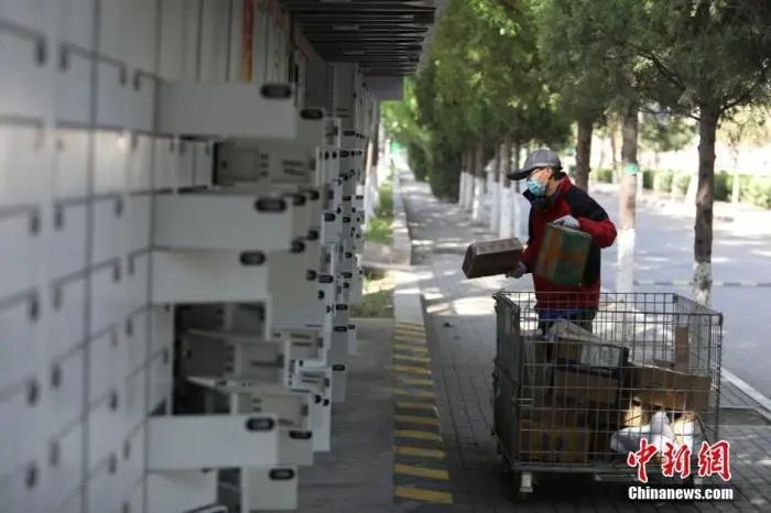 资料图：工作人员将快递放进快递柜。中新社记者 蒋启明 摄