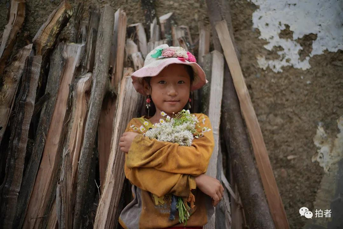 △2019年8月，特土社，9岁的吉克石里在家门口抱着一把放羊时摘的花。