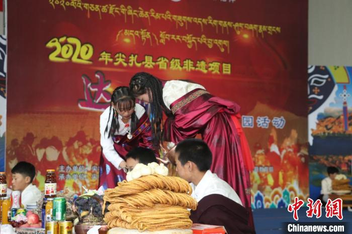 图为身着藏族的女学生为“客人”斟满奶茶。　潘雨洁 摄