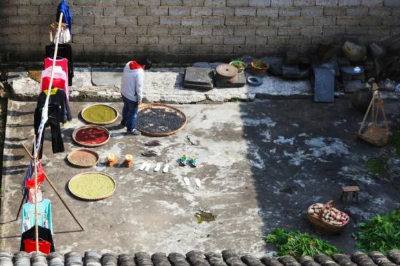 ▲ 上图：婺源游山村人家，典型的徽派建筑墙面。摄影/于永乐；下图：梅雨季歙县晒衣服和粮食的家庭。摄影/李孝祥