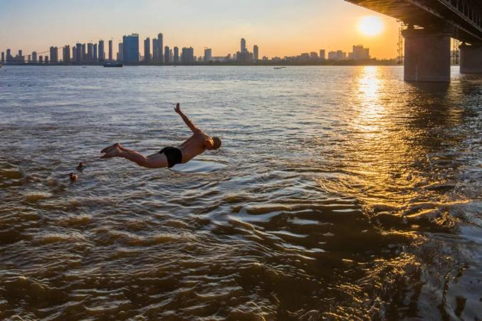 ▲ 生活在火炉城市，江边长大的武汉人自有变凉爽的办法。 摄影/宁波，供图/HANS汉声