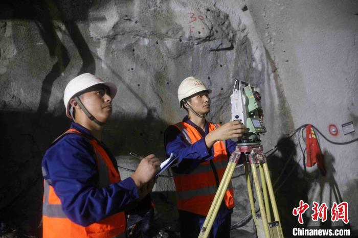 图为中铁隧道局技术人员在高黎贡山隧道1号斜井内监控测量。　黄再云 摄
