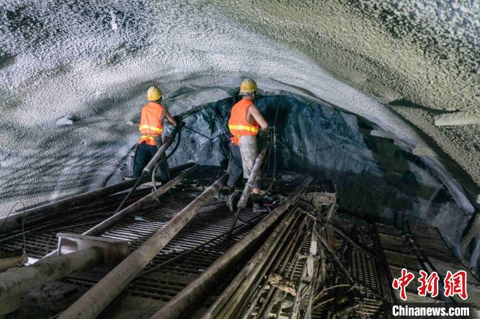 图为施工人员正在斜井掌子面进行风钻作业。　黄再云 摄