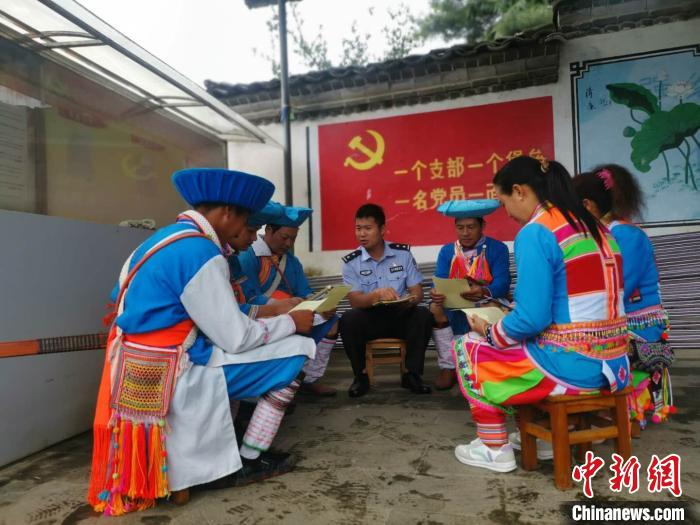 图为屈斌(中)向傈僳族群众普法 钟欣 摄