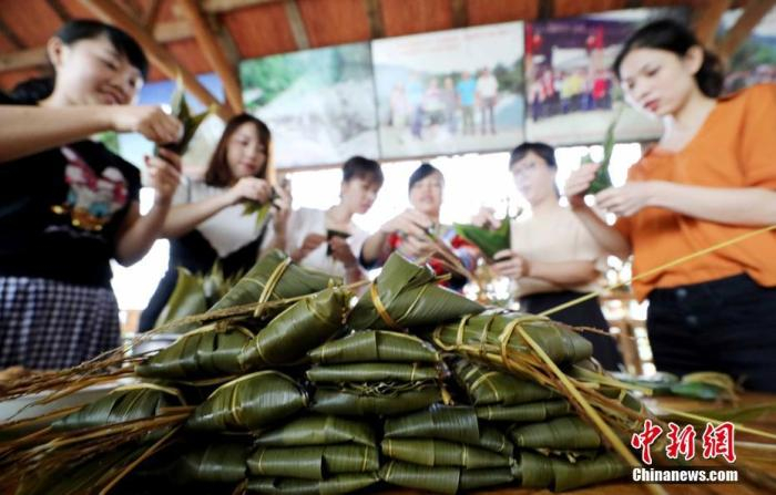 资料图：游客在学习制作五彩粽子。谭凯兴 摄