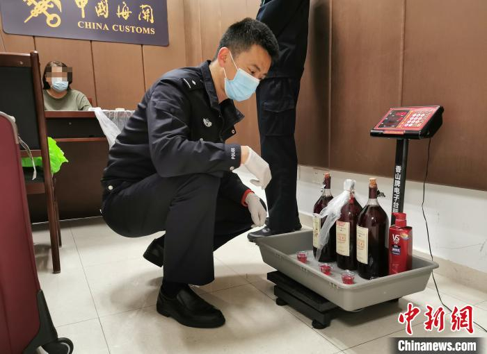 广州海关缉私警察对藏匿在红酒瓶和洗发水瓶中的毒品进行称量 关悦 摄