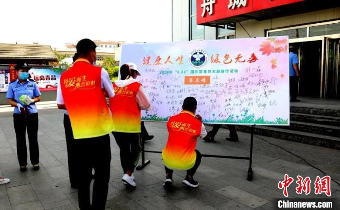 岢岚县彩虹禁毒社工在签名墙上签名。　岢岚县社区戒毒社区康复服务中心供图