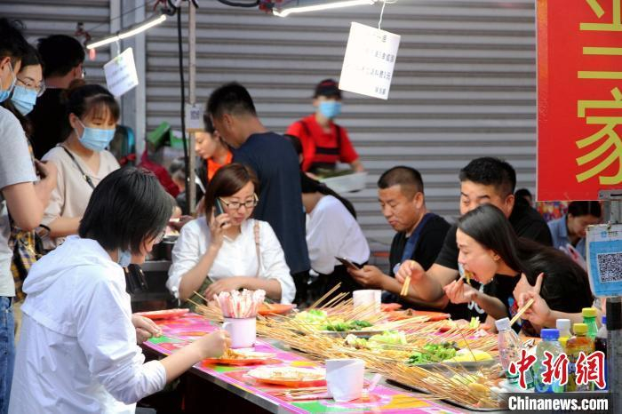 资料图：济南市民在小吃摊大饱口福。 孙宏瑗 摄