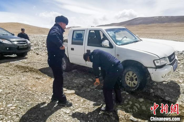 图为派出所民警在无人区救助被困车辆。　普玛江塘边境派出所 供图