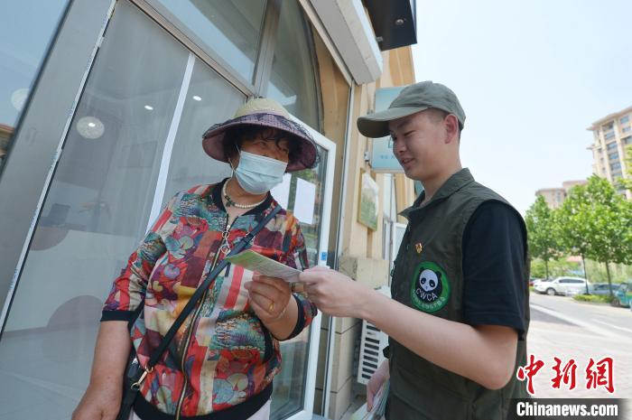 志愿者向民众发放保护野生动物宣传单。　王海滨 摄