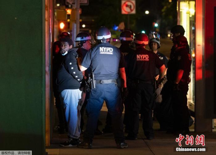 资料图：当地时间6月2日，美国纽约进入宵禁后，警察在街上拘捕了部分未执行规定的人。