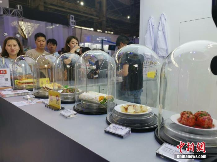 资料图：某展会“人造肉”制作的食品展台吸引参观者驻足。中新社记者 张茵 摄