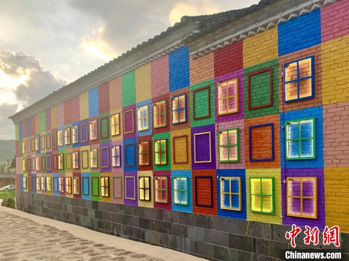 图为村里的艺术墙“万家灯火”。　黄小桐 摄