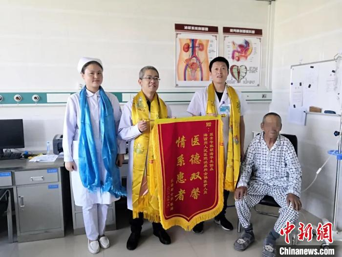 胡海平(左二)收到病人赠送的锦旗。　浙江医院供图 