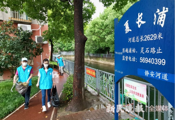 图说：河长朱长中（前右）和志愿者一起巡河。周馨 摄