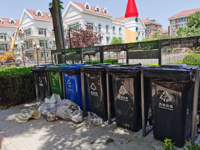 小区内的集中投放点，过了集中投放的时间段，居民将垃圾就扔在垃圾桶外。摄 新京报记者 陈琳