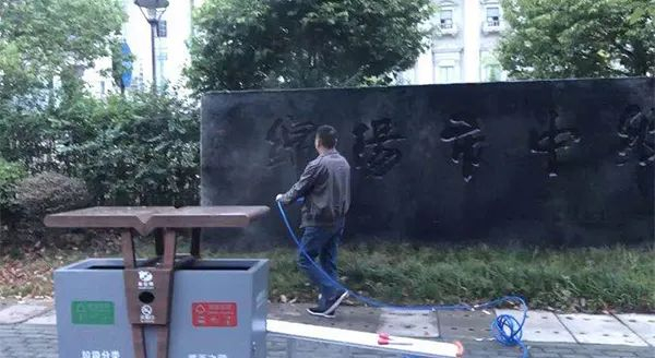  男子用事先准备好的黑色乳胶漆将法院牌匾涂黑