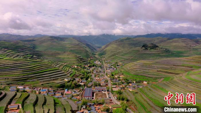 图为被梯田包围的村庄。　韦德占 摄