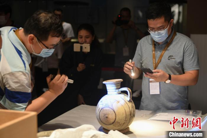 专家鉴定“单耳几何纹茧形壶”。　杨华峰 摄