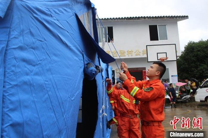 消防救援人员在古登村委搭建临时帐篷。　黄欢玉 摄