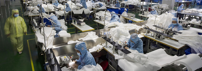 疫情期间，工人们在亚都集团的防护服生产车间里紧张忙碌着。 资料图 