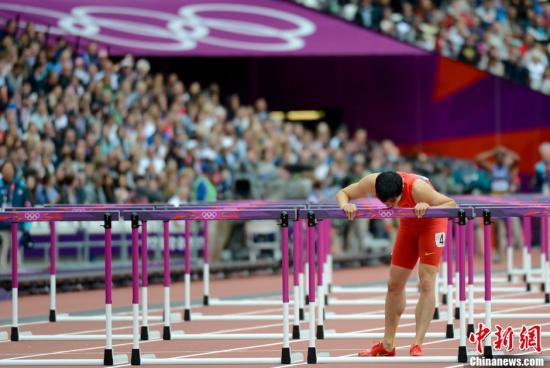 资料图：当地时间2012年8月7日，伦敦奥运会男子110米栏预赛，刘翔意外摔倒无缘半决赛，亲吻栏架告别伦敦奥运。 中新社发 廖攀 摄