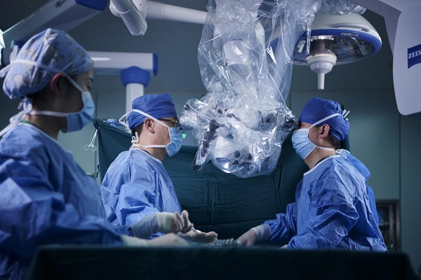 图说：“上海工匠”、公利医院骨科主任杨铁毅（左二）在显微镜下进行精细化脊柱手术  采访对象供图