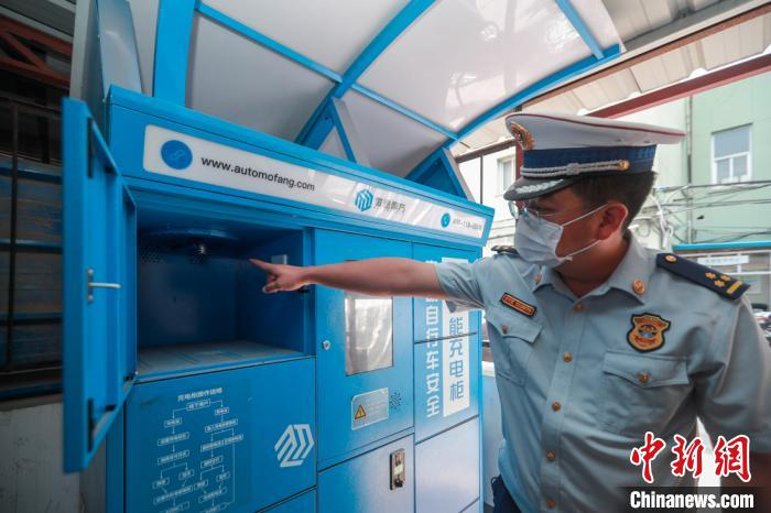 图为李禹江介绍电动自行车集中充电柜。　贾天勇 摄