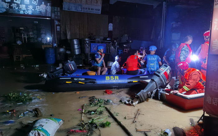 鄱阳县油墩村，洪水中杂物众多，救援艇前进难度颇大。受访者供图