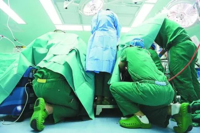 △为了避免李华身体不稳定而导致神经损伤致截瘫等风险，几位医生跪趴着帮助李华稳定身体。