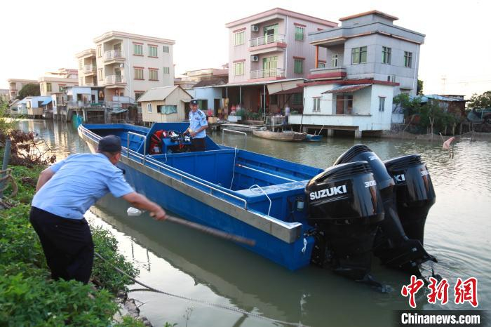 海关缉私警察准备押送“大飞”沿河涌转移 关悦 摄