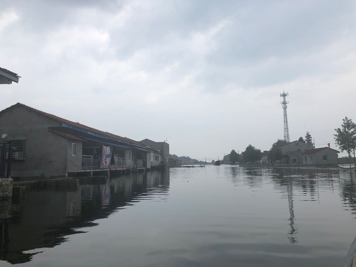 在洪湖水未涌入村内，这片区域有一条河，河边有可以通车的水泥路。