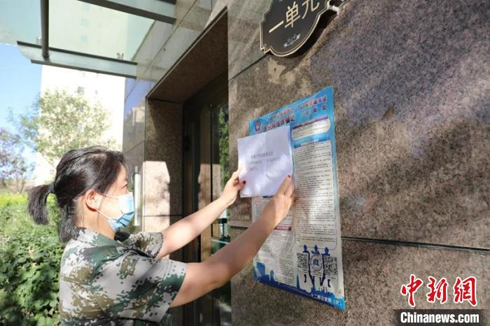 社区工作人员张贴疫情防控宣传资料。第十二师供图