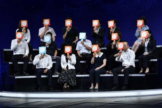 《问政山东》节目现场，由山东省人大代表、省政协委员和群众代表组成的问政代表团集体举牌，对菏泽市市长陈平的回答表达意见，红色“笑脸”标志表示满意，蓝色“哭脸”标志表示不满意。图片由《问政山东》节目组提供