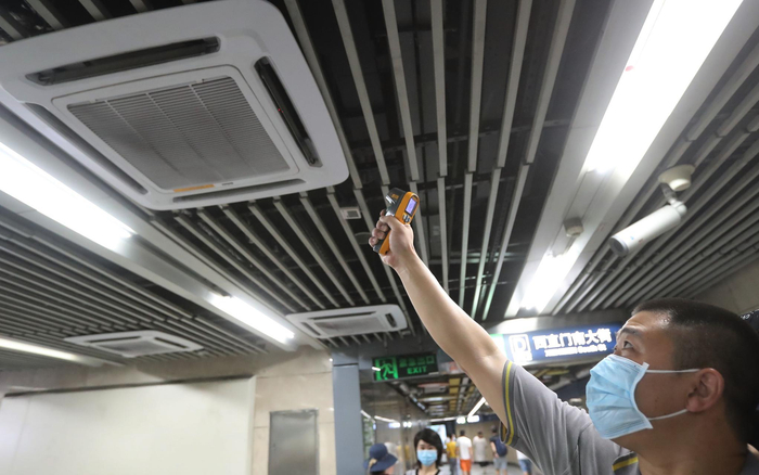 工作人员利用红外线测温仪测量空调出风口的温度是否合格。摄影/新京报记者 王贵彬