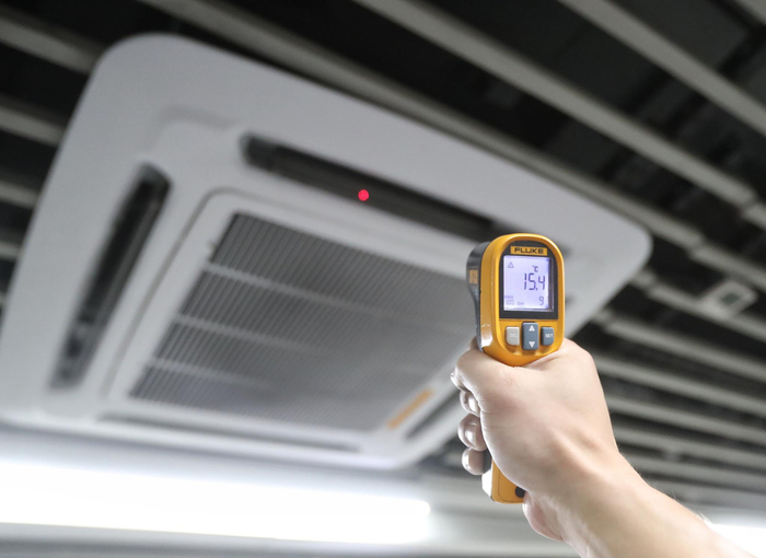 红外线测温仪显示，空调出风口的温度为15.4℃。摄影/新京报记者 王贵彬