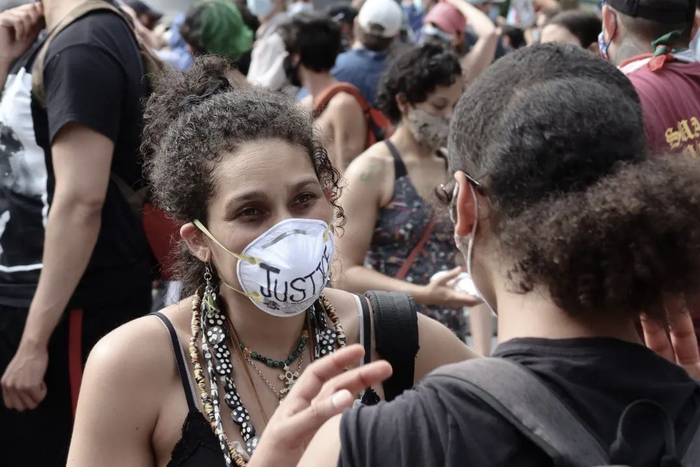 ▲一位参与示威的白人女性戴着写有“JUSTICE”（公正）字样的口罩。摄影/新京报拍者 Bobo