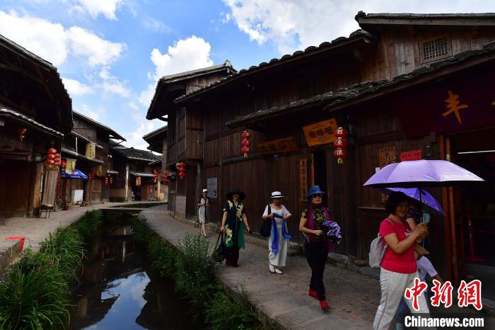 图为7月21日，游客在鲤鱼溪景区参观游玩。鲤鱼溪村景幽雅，古民居群青瓦夯墙，保留明清水乡建筑特色。　张斌 摄