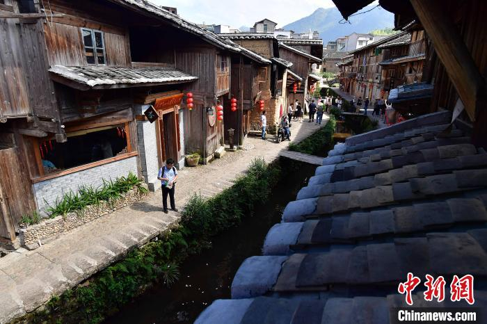 图为7月21日，游客在鲤鱼溪景区参观游玩。鲤鱼溪村景幽雅，古民居群青瓦夯墙，保留明清水乡建筑特色，是“中国传统村落”和“中国历史文化名村”。　张斌 摄