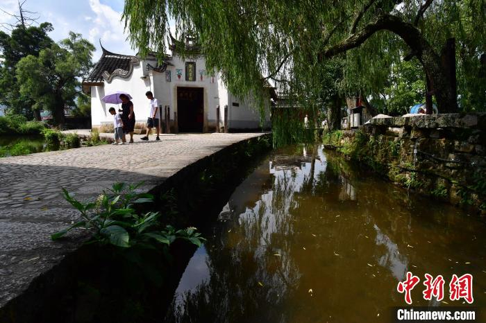 图为7月21日，游客从郑氏宗祠前经过。浦源郑氏宗祠是一处始建于宋代的宗族祠堂建筑，是福建省重点文物保护单位。　张斌 摄