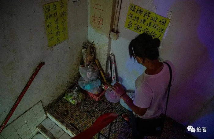 ▲黄凤绕过楼道里堆放的垃圾下楼。