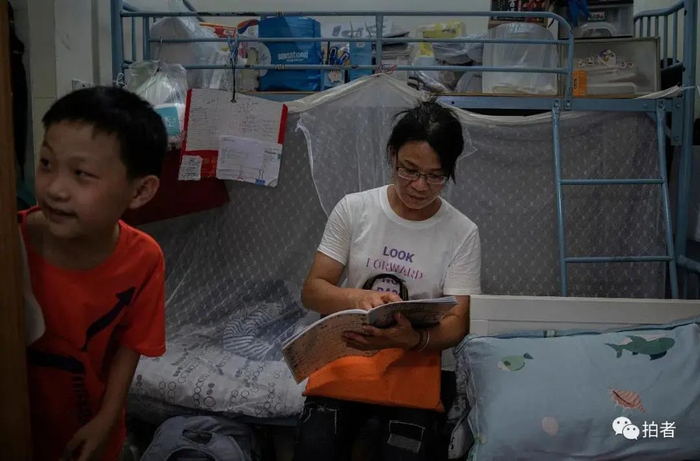 ▲黄凤每天都会检查儿子的作业。她说，孩子的数学和语文还可以，就是英语有点跟不上。为了辅导孩子，她也会去社区中心学习免费的英语课程。