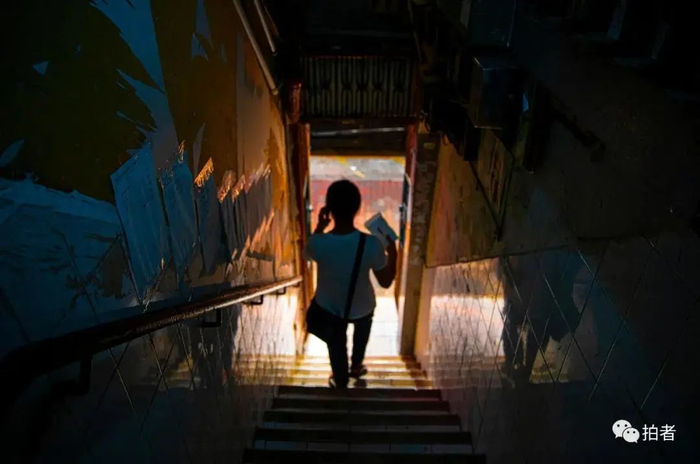 ▲黄凤走出阴暗破旧的楼道。