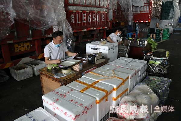 图说：凌晨五点，摊位老板等待批发商上门批货 新民晚报记者 王凯 摄