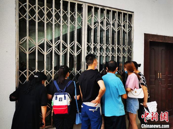 没能进入审现场旁听群众站在审判庭外关注案件庭审。　苗志勇 摄